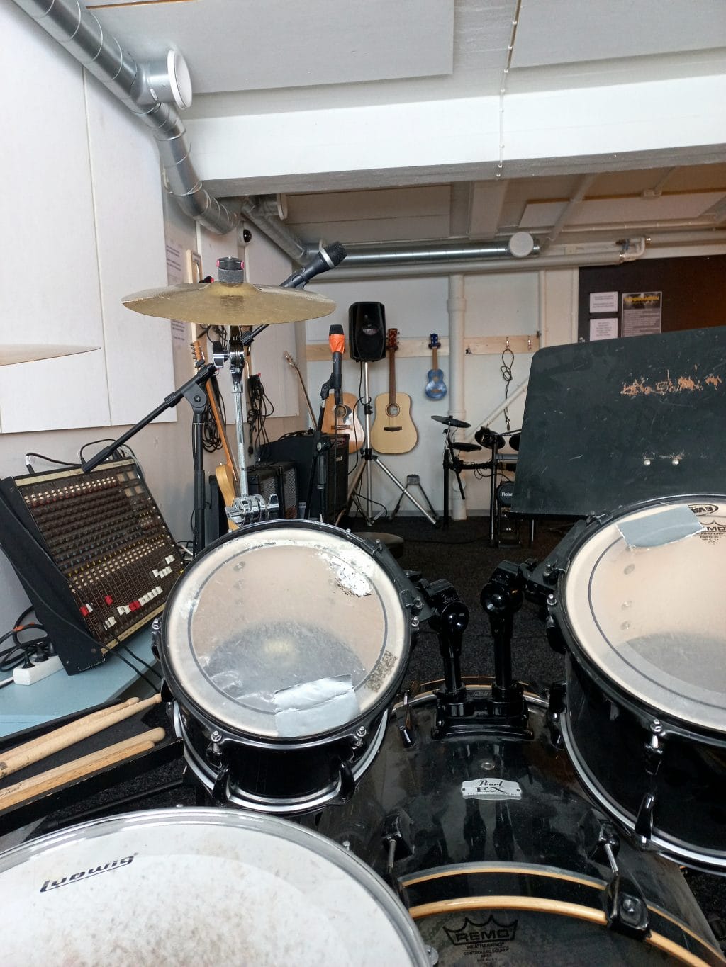 Kuva nuorisotoimen bänditilasta. Kuvassa soittimia yms. musiikin soittamiseen tarvittavia välineitä