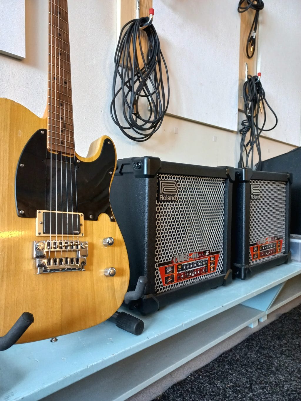 Kuva nuorisotoimen bänditilasta. Kuvassa vahvistimia ja sähkökitara.