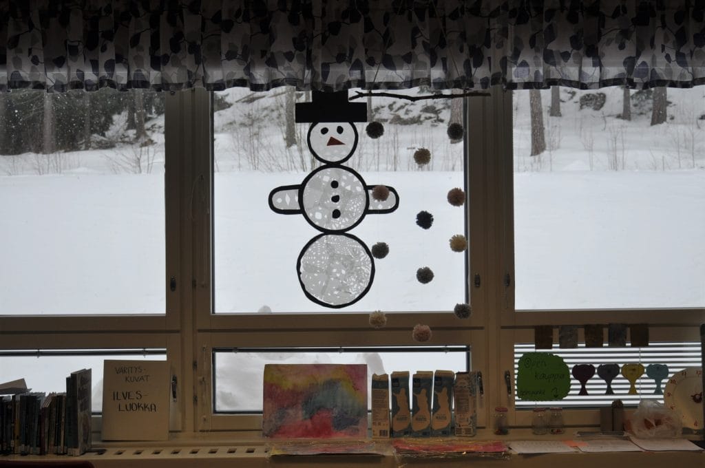 Valokuva Eskon koulun luokkahuoneesta. Ikkunalaudalla ja ikkunalla kuvataiteessa tehtyjä oppilastöitä. Esimerkiksi suuri lumiukko.