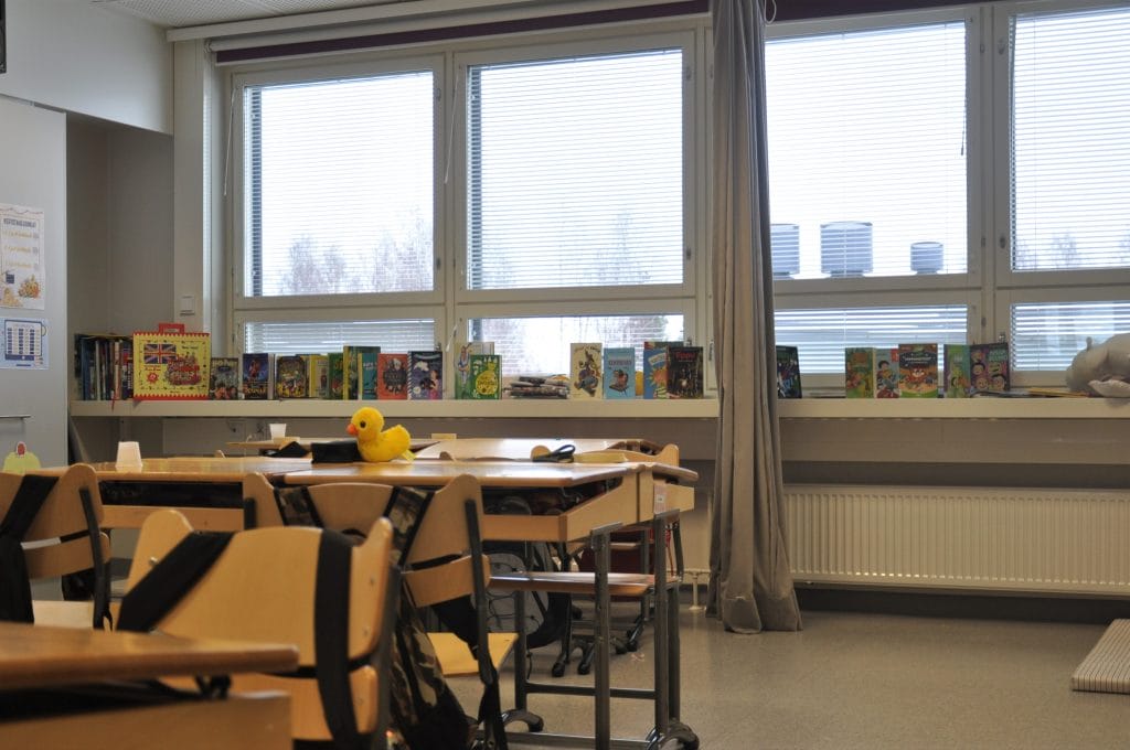 Valokuva Eskon koulun luokkahuoneesta. Kuvassa näkyy pulpetteja ja ikkulaudalle näytteille asetettuja kirjoja.